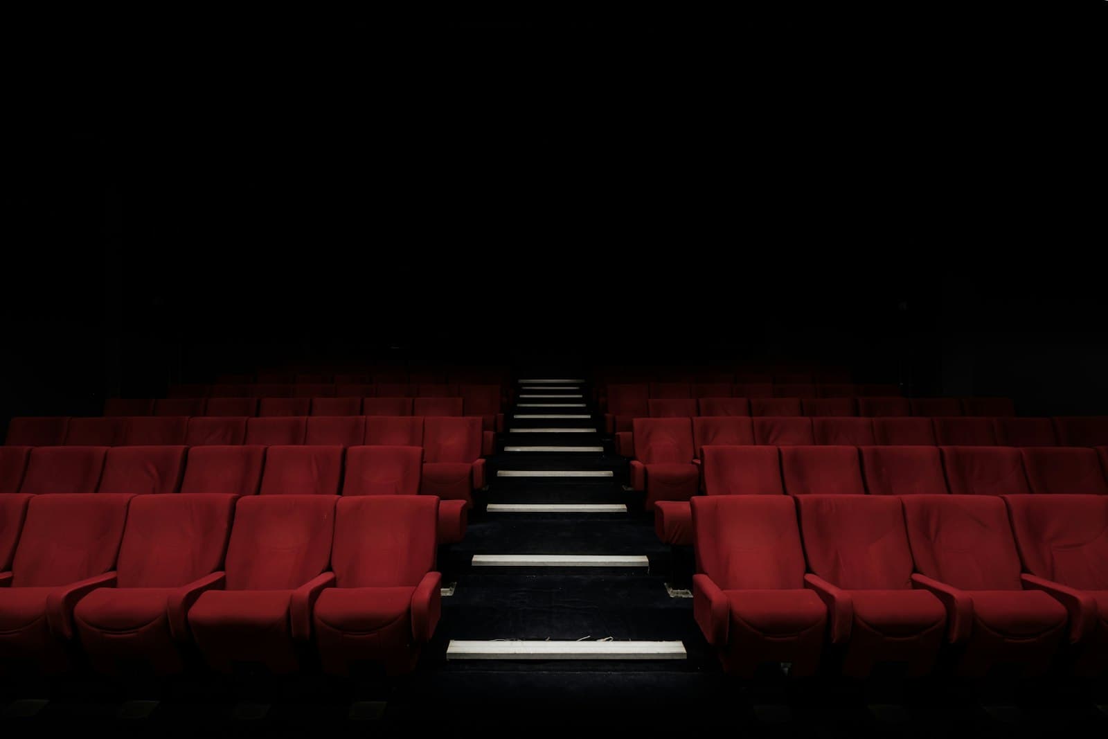 Sala a oscuras, un haz de proyector atraviesa el polvo