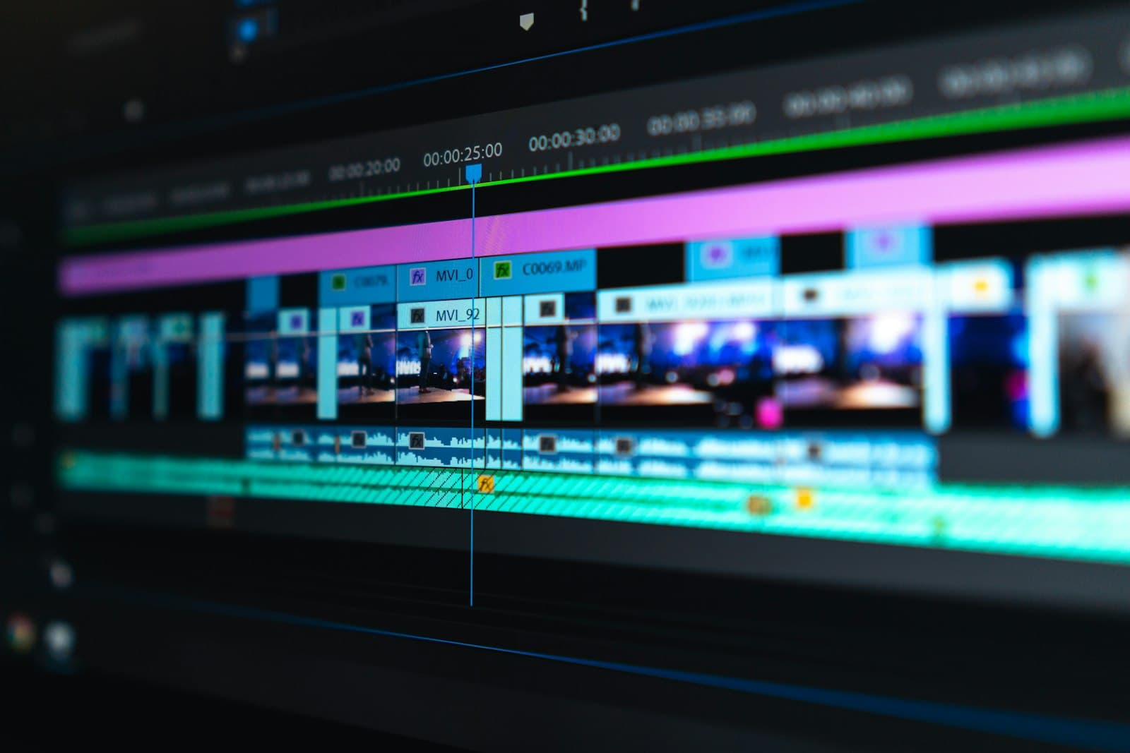 Timeline de edición sobre un monitor, manos en el teclado